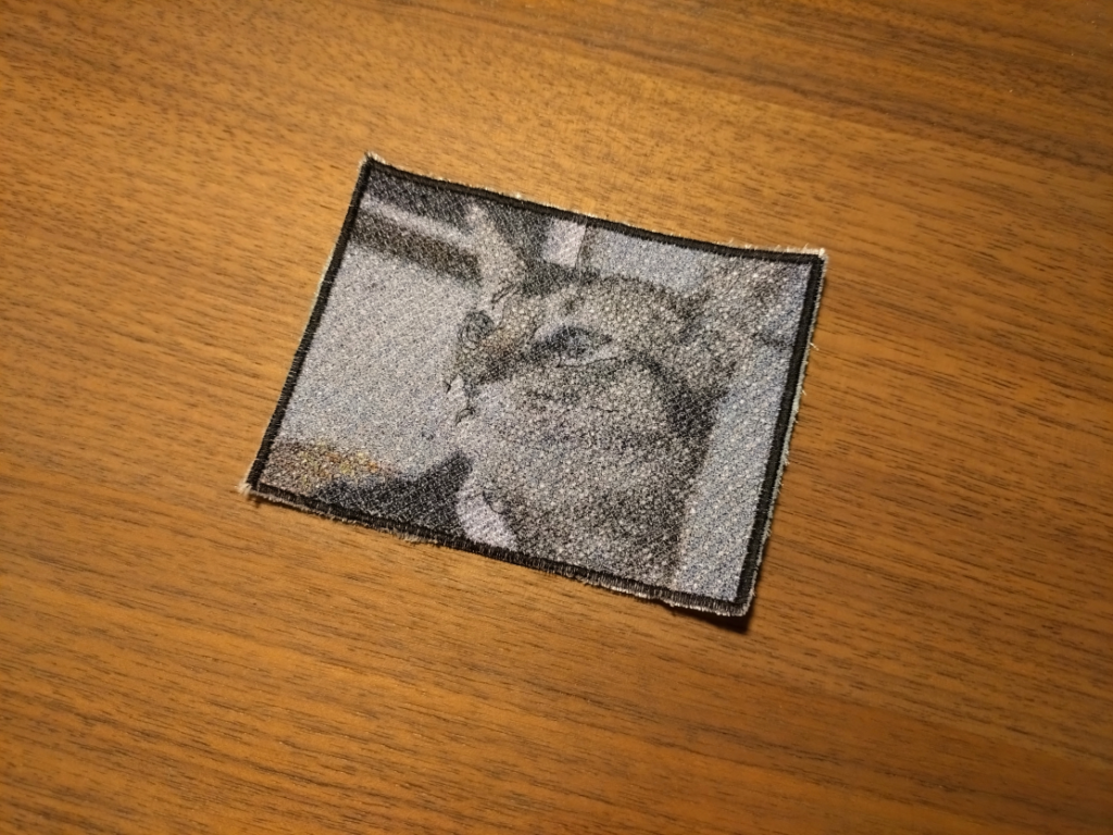 Fotorealistischer Fadenkunst-Patch einer Katze im Anzug nach Björk, Graustufen, 11x8 cm